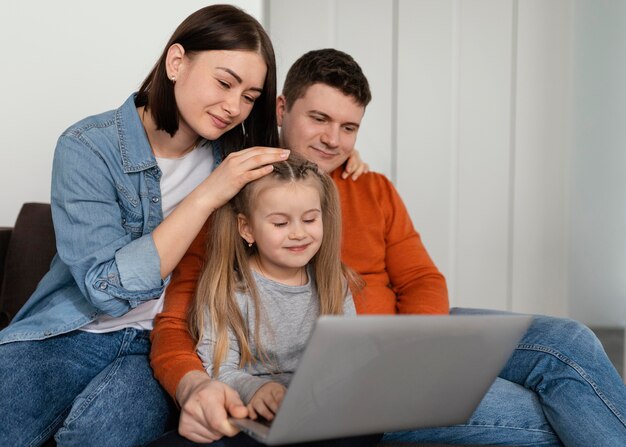 Padres y niños de tiro medio con laptop