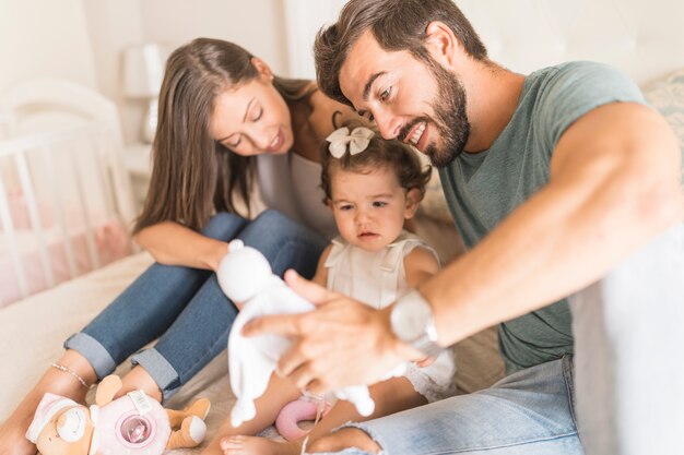 Padres ofreciendo juguetes a su hija