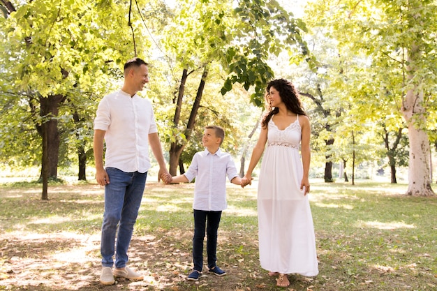 Padres paseando por el parque con su hijo