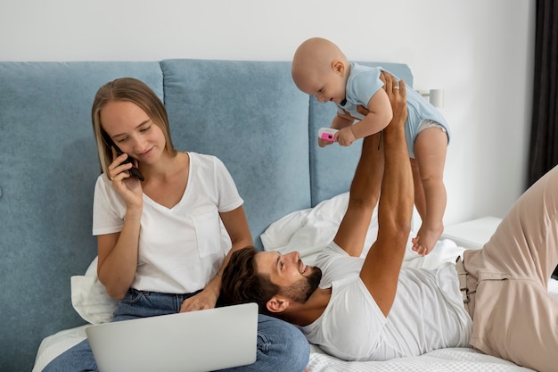 Padres que trabajan en la computadora portátil desde casa durante la cuarentena con el niño