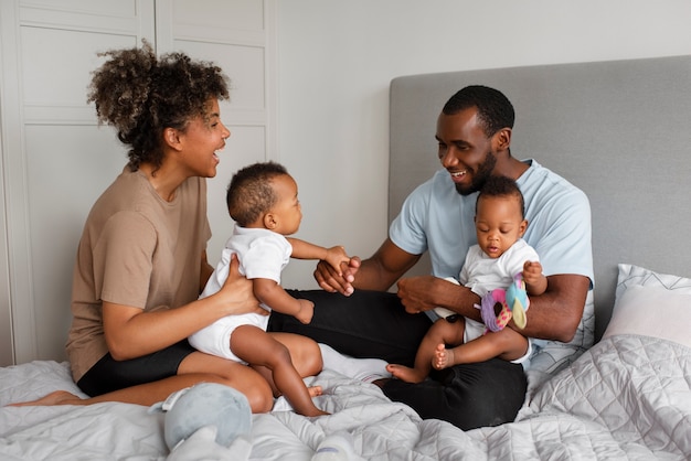 Padres sonrientes de tiro completo con bebés