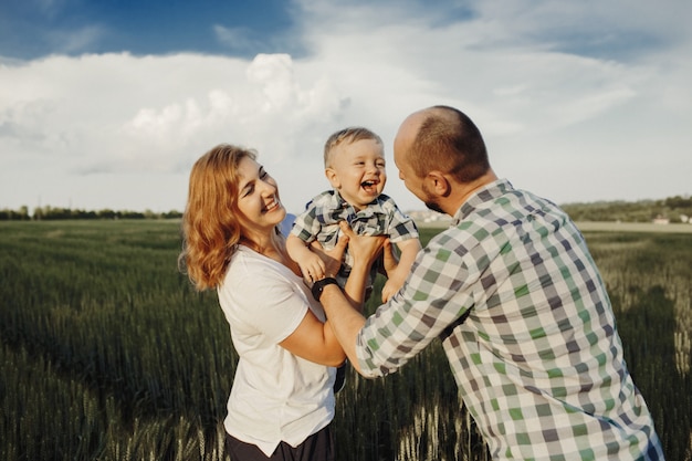 Los padres sostienen a su pequeño hijo y se ven muy felices