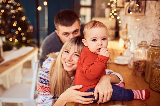 Padres con su adorable hijo en una sesión de fotos navideña