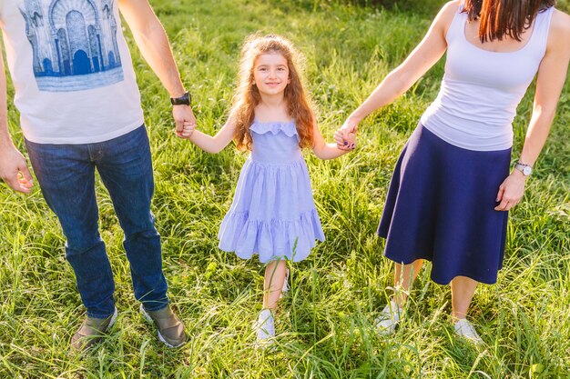 Padres con su hija de la mano en el parque