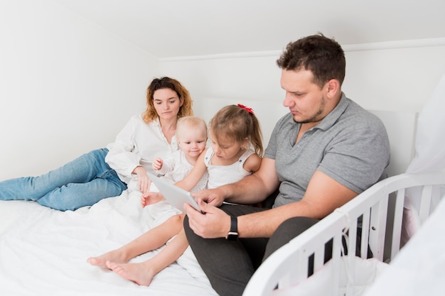 Padres con tableta en la cama