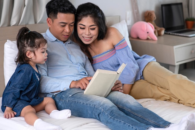 Padres de tiro medio leyendo al niño