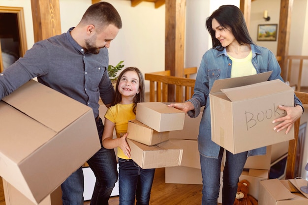 Padres de tiro medio y niño con cajas.