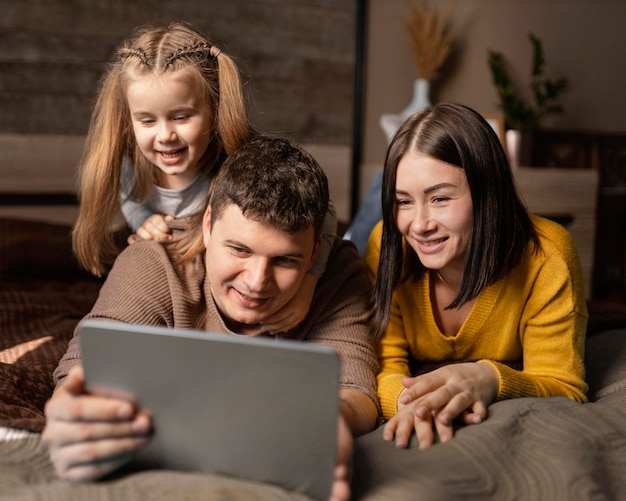 Padres de tiro medio y niño con tableta