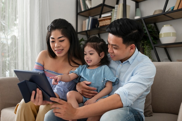 Padres de tiro medio y niño con tableta