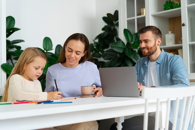 Foto gratuita padres de tiro medio que trabajan de forma remota