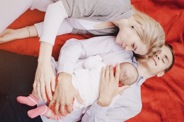 Foto gratuita padres tumbados con su bebé