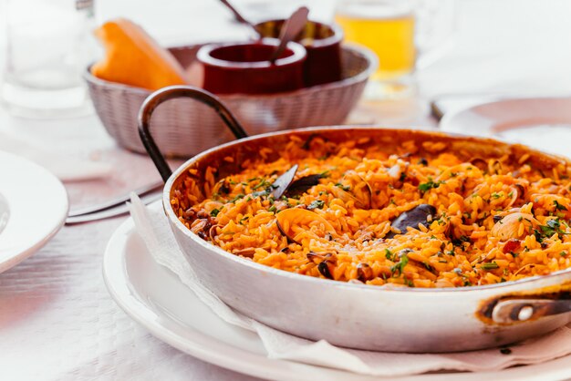 Paella española de mariscos con mejillones, camarones, etc. en una paellera de acero. Canarias cocina en un pequeño restaurante familiar.