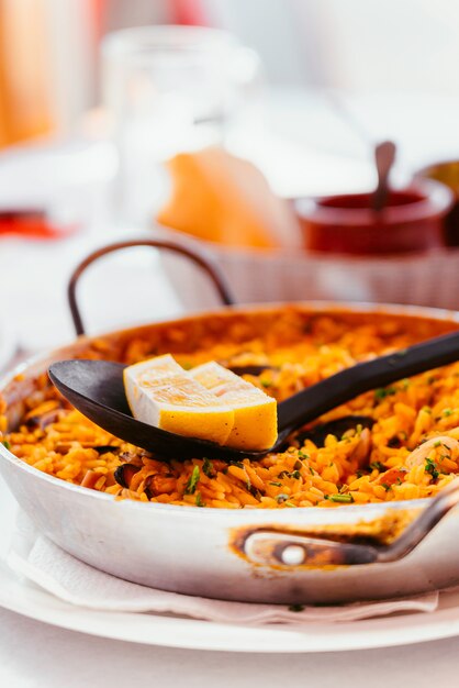 Paella española de mariscos con mejillones, camarones y un trozo de limón. en una paellera de acero. Canarias cocina en un pequeño restaurante familiar.