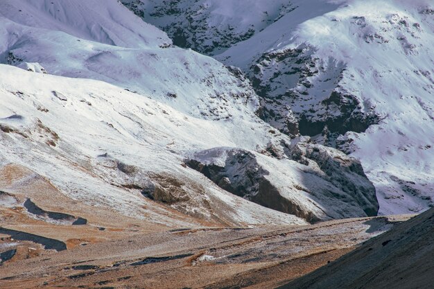 Paisaje agreste de las montañas rocosas cubiertas de capas de nieve.