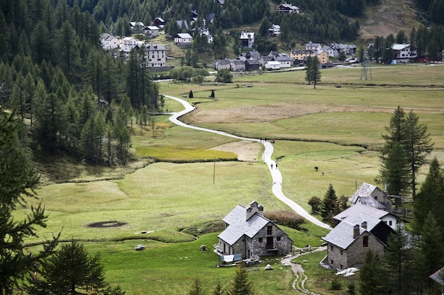 Paisaje de la aldea rodeada de colinas cubiertas de vegetación durante el día