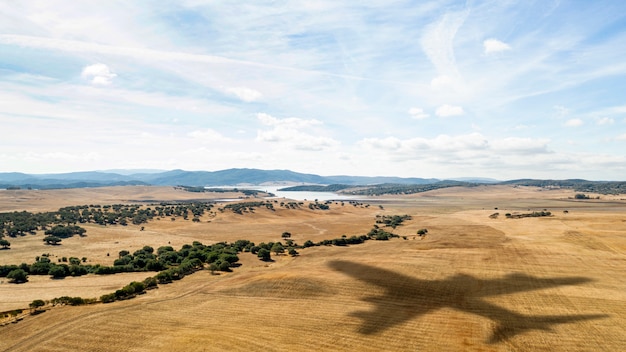 Paisaje con avión volando en el cielo