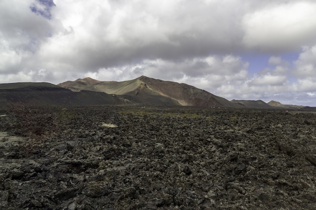 Paisaje de colinas bajo un cielo nublado en el Parque Nacional de Timanfaya en España