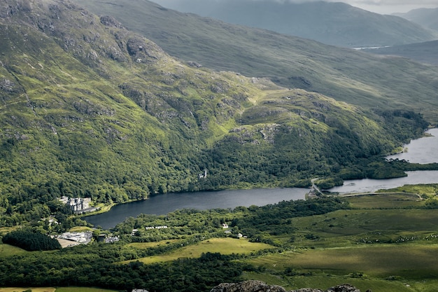 Foto gratuita paisaje de las colinas cubiertas de vegetación bajo un cielo nublado en el parque nacional de connemara, irlanda