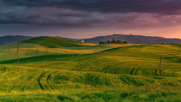 Paisaje de colinas cubiertas de vegetación durante una hermosa puesta de sol