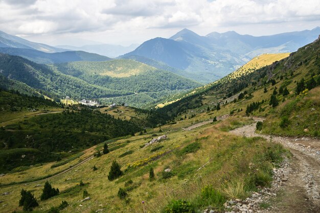 Paisaje de colinas cubiertas de vegetación con montañas rocosas