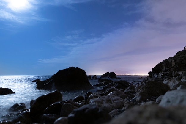 Paisaje costero en la noche con rocas