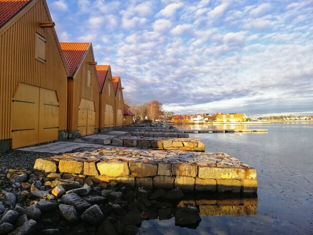 Paisaje de edificios alrededor del lago bajo el cielo nublado en Stavern Noruega