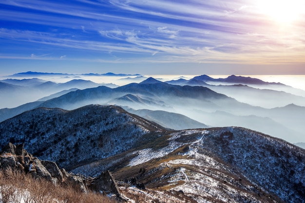 Paisaje invernal con puesta de sol y niebla en las montañas Deogyusan, Corea del Sur