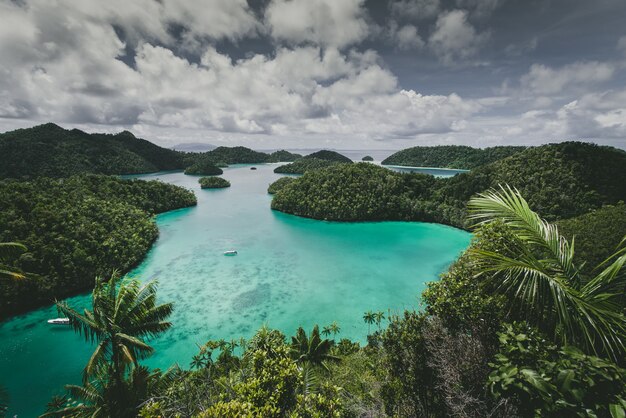 Foto gratuita paisaje de la isla wajag rodeada por el mar bajo un cielo nublado en indonesia