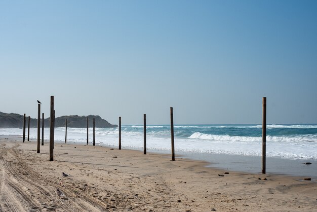 Paisaje de un mar con columnas de madera rodeado por el mar