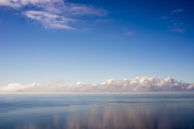 Paisaje del mar bajo la luz del sol con las nubes reflejándose en el agua en Portugal