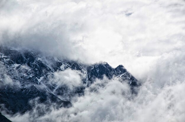 Paisaje de montaña con niebla y cielo nublado.