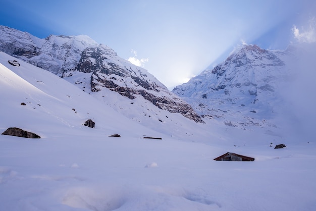 Paisaje de montañas rocosas cubiertas de nieve bajo un cielo nublado