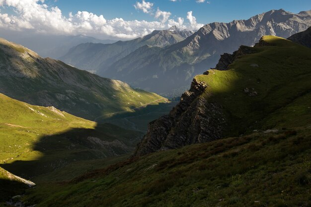 Paisaje de montañas rocosas cubiertas de nieve bajo la luz del sol y un cielo nublado