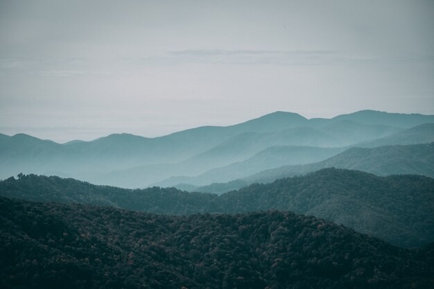 Paisaje montañoso brumoso bajo el cielo sombrío