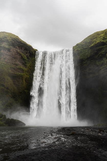 Paisaje de naturaleza nublada cerca de cascada