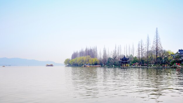 Paisaje otoñal con río y árboles sin hojas