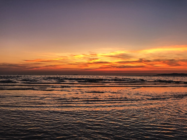 Paisaje de puesta de sol en la playa con olas calmantes del océano