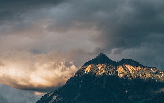 Paisaje de rocas cubiertas de bosques bajo la luz del sol y un cielo nublado