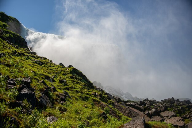 Paisaje de rocas cubiertas de musgo con las Cataratas del Niágara bajo la luz del sol