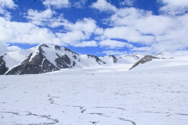 Paisaje de rocas cubiertas de nieve bajo la luz del sol y un cielo nublado