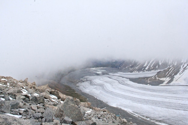 Paisaje de rocas cubiertas de nieve y niebla durante el día en invierno