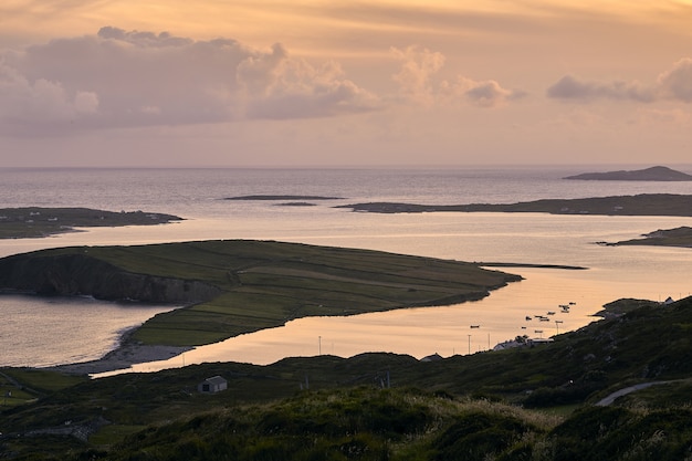 Paisaje del Sky Road rodeado por el mar durante la puesta de sol en Clifden en Irlanda