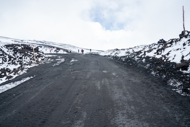 Paisaje de terreno salvaje volcán Etna con caminos de nieve y ceniza en la cima del volcán