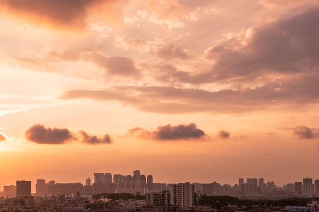 Paisaje urbano de una ciudad bajo un cielo nublado durante la puesta de sol por la noche