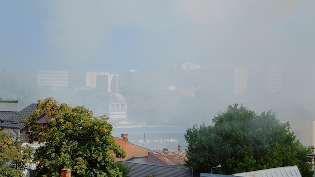 Paisaje urbano de la ciudad con humo de la casa en llamas. Vista de la ciudad con smog y humos del edificio en llamas. Aire con vapor y llamas por accidente con incendio peligroso en la ciudad.