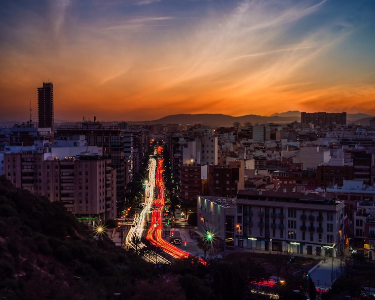 Foto gratuito paisaje urbano de una ciudad moderna rodeada de luces con larga exposición durante una hermosa puesta de sol