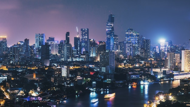Paisaje urbano del horizonte de la ciudad de bangkok en la noche con rayas de luz de barco en tailandia,