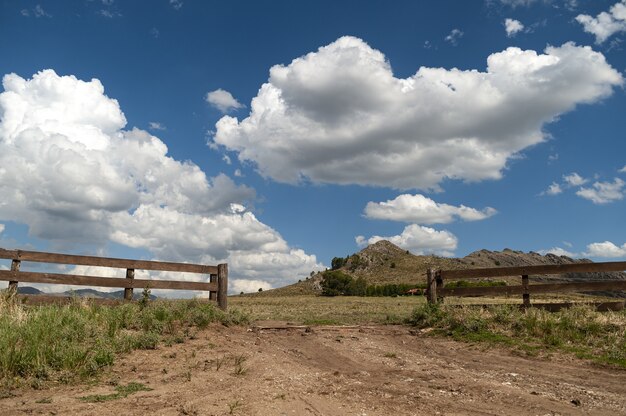 Paisaje del valle con una valla de madera abierta bajo el cielo nublado