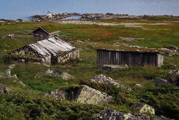 Paisaje verde con graneros de madera cerca de un lago en Noruega