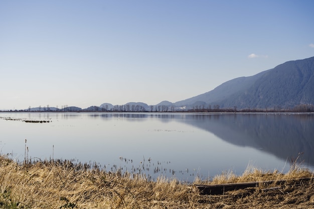 Paisaje de Wigeon Slough rodeado de colinas bajo la luz del sol en la Columbia Británica, Canadá